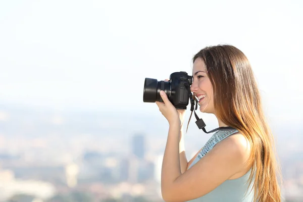 屋外のデジタル一眼レフ カメラで写真を撮る幸せな写真家の側面ビュー肖像画 — ストック写真