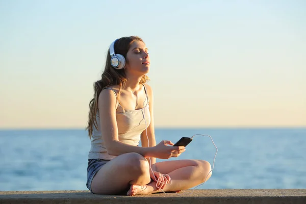 Полный Портрет Девушки Расслабляющей Слушая Музыку Смартфона Сидящей Скамейке Пляже — стоковое фото