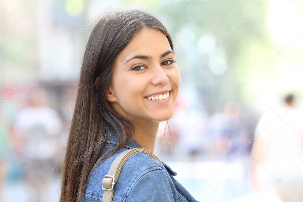 Portrait of a happy teenage girl looking at camera outdoor in the street