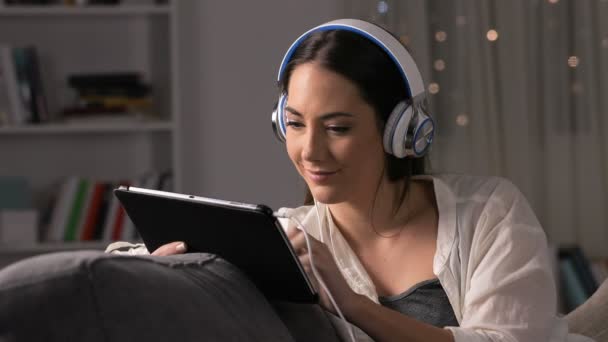 Podekscytowana Kobieta Noszenia Słuchawek Znajdowanie Treści Online Tablecie Siedzi Kanapie — Wideo stockowe