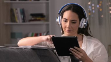 E-öğrenme ciddi öğrenci tablet ve gece evde bir kanepede oturan defter kullanma