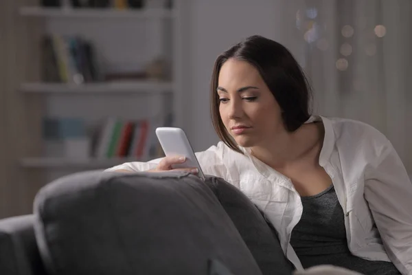 Verveelde Vrouw Controleren Smart Phone Content Zitten Een Bank Nacht — Stockfoto