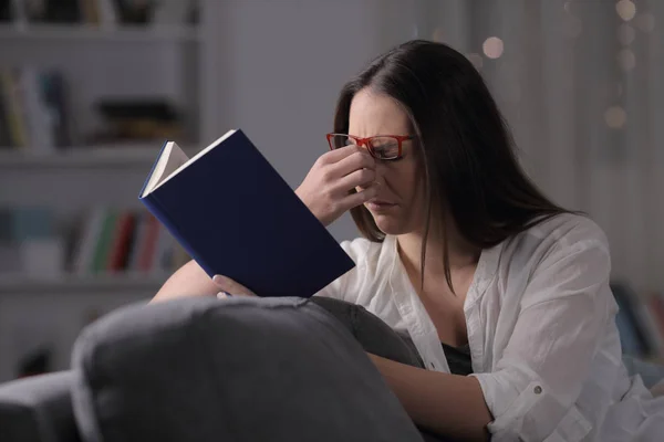 Κυρία Γυαλιά Που Υποφέρει Διαβάζοντας Ένα Βιβλίο Κάθεται Έναν Καναπέ — Φωτογραφία Αρχείου