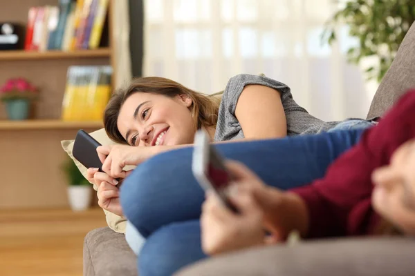 Two Happy Roommates Using Smart Phones Lying Couch Home — Stock Photo, Image