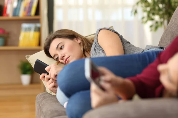 Vážní Přátelé Pomocí Svých Chytrých Telefonů Ležící Gauči Doma — Stock fotografie