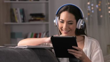 Tablet ve gece evde bir kanepede oturan defter ile e-öğrenme mutlu öğrenci
