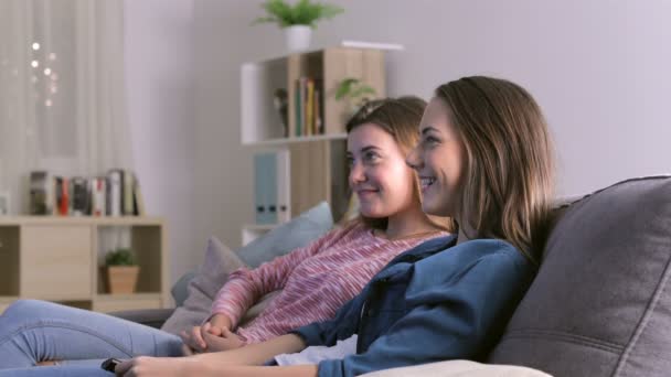 Dos Chicas Emocionadas Viendo Televisión Sentadas Sofá Casa Noche — Vídeo de stock