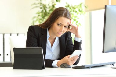Bir masa üzerine birden çok aygıt kullanarak çalışma endişe ofis çalışanı