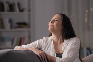 Mutlu kadın temiz hava soluyor gecenin bir yarısı bir kanepede oturuyor.