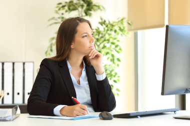 Düşünceli ofis çalışanı iş yerindeki pencereden başka yere bakıyor.