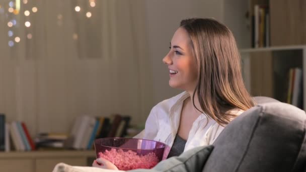 Zijaanzicht Van Een Opgewonden Vrouw Eten Popcorn Zittend Een Bank — Stockvideo