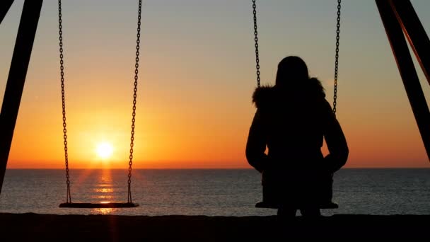 在海滩上的日落时 一个悲伤的女人独自错过了她失去的伴侣的背景画 — 图库视频影像
