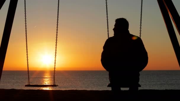 一个悲伤的人独自在海滩上看着空座位的背景 — 图库视频影像