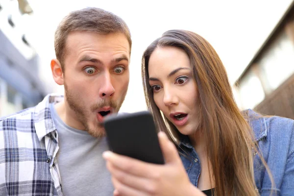 Front View Portrait Surprised Couple Checking Online News Smarphone Street — стоковое фото