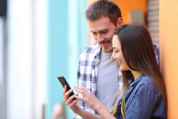 Happy Couple Browsing Smart Phone Content Leaning Wall Street — Stock Photo, Image