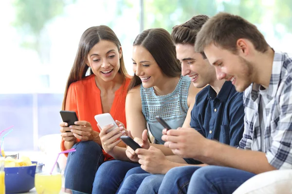 Glada Grupp Vänner Kontrollera Smarta Telefoner Som Sitter Soffa Vardagsrummet — Stockfoto