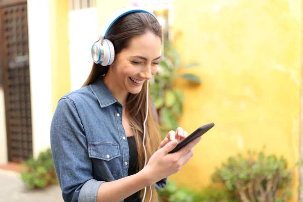 Mujer Feliz Escuchando Música Usando Teléfono Inteligente Caminando Por Calle —  Fotos de Stock