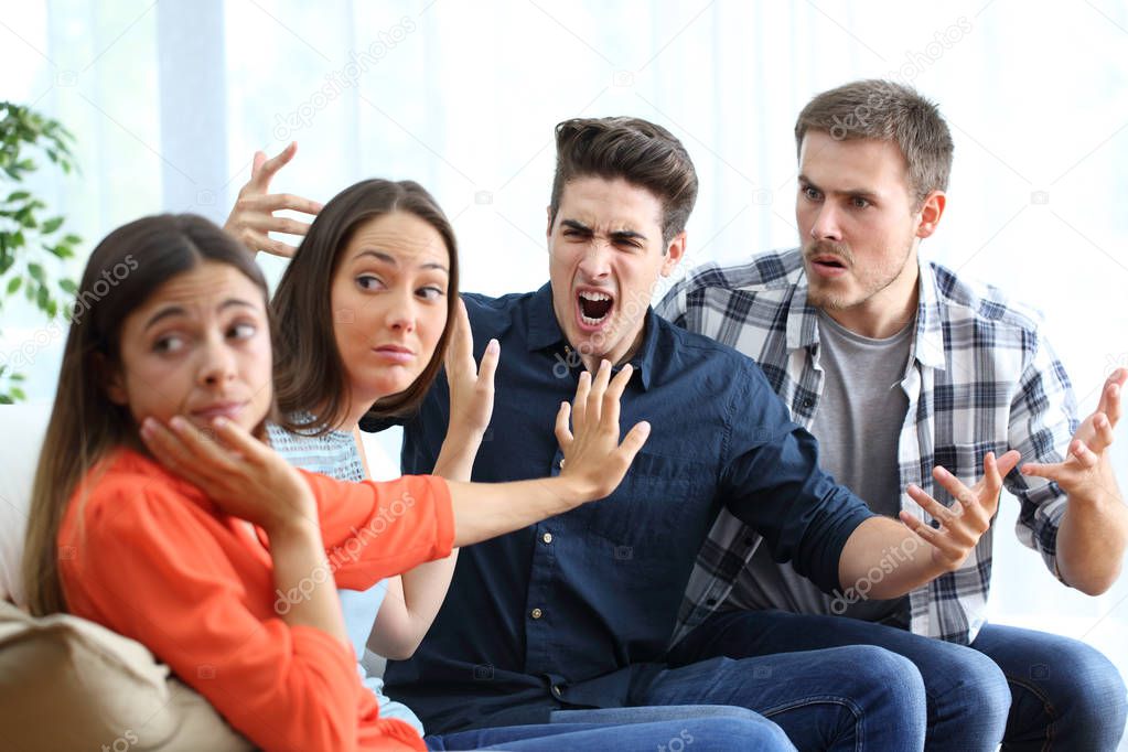 Two angry women ignoring men arguing at home