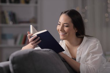 Mutlu kiracı gece evde kitap okurken