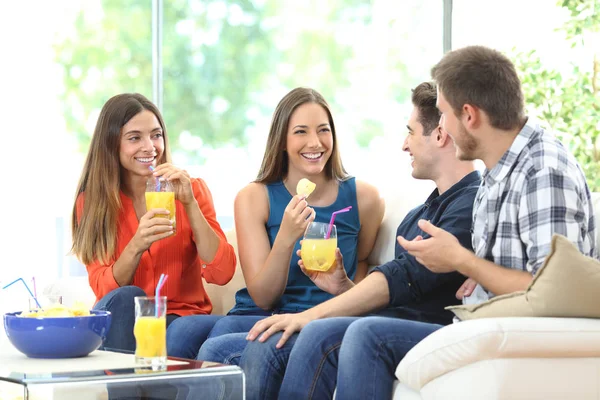 Grupo de amigos hablando comiendo y bebiendo en casa —  Fotos de Stock