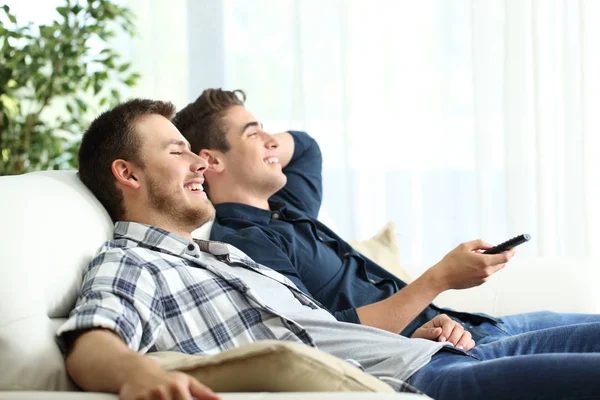 Dos amigos viendo la televisión relajándose en casa —  Fotos de Stock