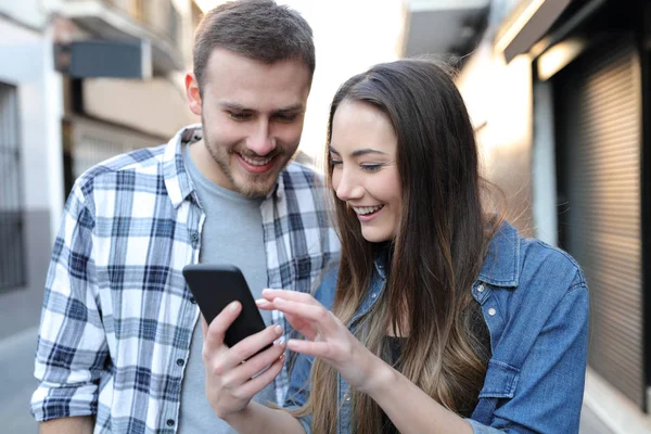 Pár okos telefon tartalom az utcán ellenőrzése — Stock Fotó