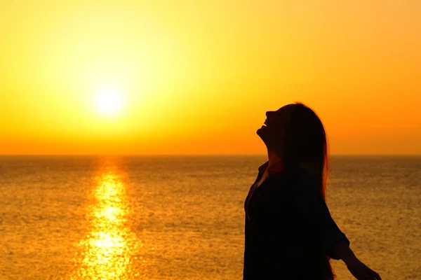 Щаслива жінка на пляжі дихає на заході сонця — стокове фото