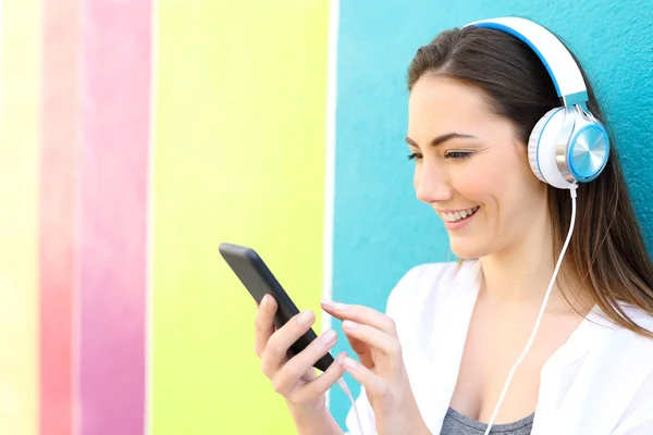 Donna felice ascolta la musica in una strada colorata — Foto Stock