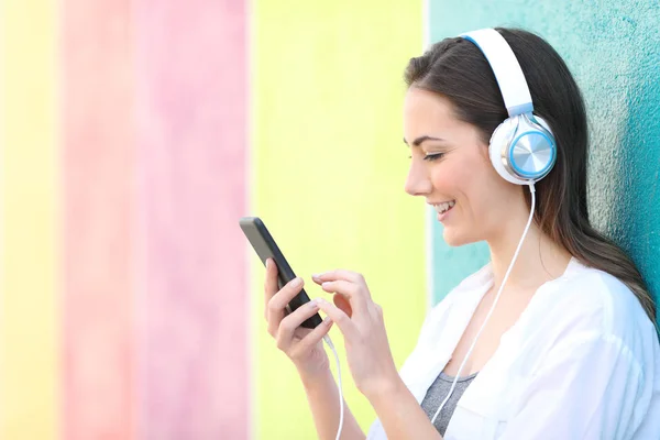 Perfil de uma menina escolhendo músicas ouvindo música — Fotografia de Stock