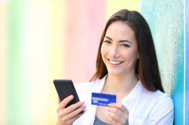 Online shopper holding phone and card looks at you clipart