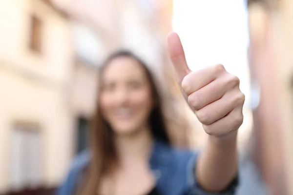 Unkonzentrierte Frau gestikuliert mit erhobenem Daumen auf der Straße — Stockfoto