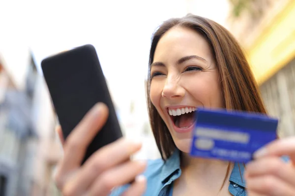 Mujer emocionada pagando en línea con tarjeta de crédito y teléfono celular — Foto de Stock