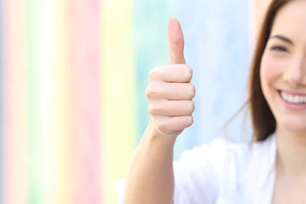 Donna felice gesticolando pollici in una strada colorata — Foto Stock