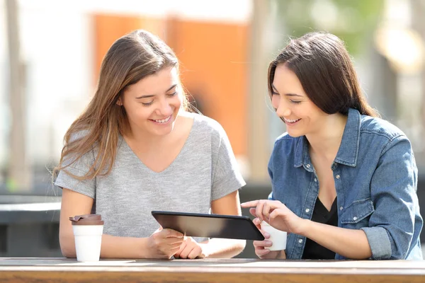 Zwei Freunde überprüfen Tablettinhalte in einem Park — Stockfoto