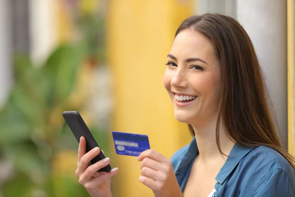 Happy buyer buys on line with credit card and looks at you — Stock Photo, Image