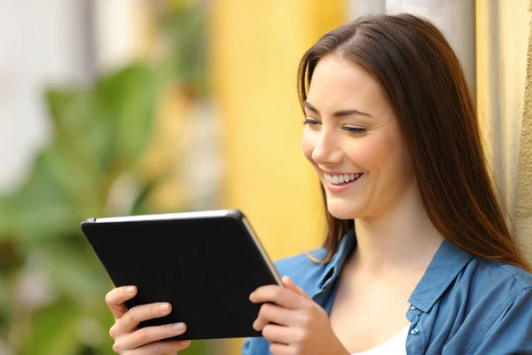 Donna felice guardando i media online su tablet per strada — Foto Stock