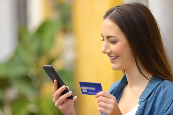 Femme heureuse payant en ligne à l'aide de carte de crédit et téléphone — Photo