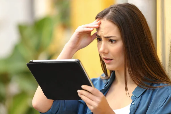 Mulher preocupada verificando o conteúdo do tablet na rua — Fotografia de Stock