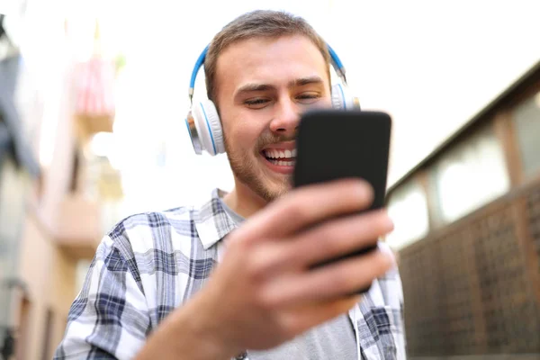 Happy man listening to music checking smart phone — Stock Photo, Image