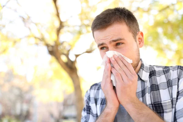 Hombre enfermo o alérgico tosiendo en un parque — Foto de Stock