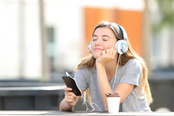 Chica relajada escuchando música sentada en un parque — Foto de Stock