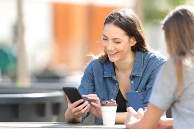 Mutlu kadın bir parkta akıllı telefon mesajları kontrol