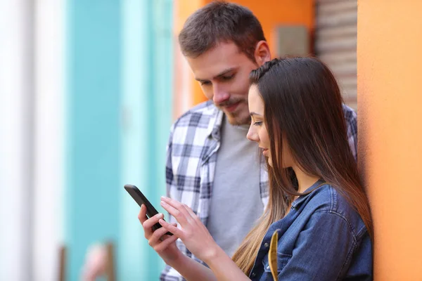 Paar checkt Smartphone-Nachrichten auf der Straße — Stockfoto