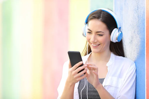 Happy woman listens to music using phone — Stock Photo, Image