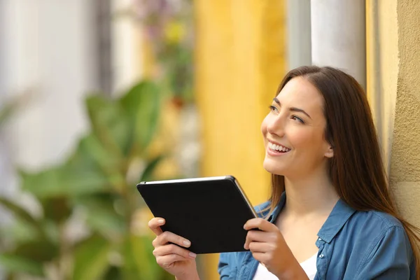 Yan görünümlü tablet düşünme tutan mutlu kadın — Stok fotoğraf