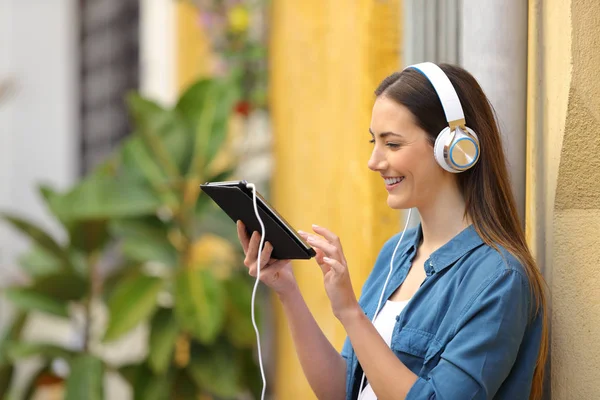 Menina feliz ouvir e assistir conteúdo tablet — Fotografia de Stock