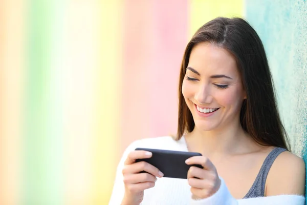 Happy woman watching videos on smartphone — Stock Photo, Image