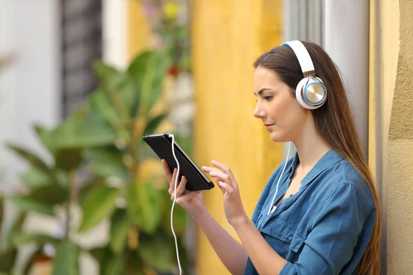 Menina grave ouvir e assistir conteúdo tablet — Fotografia de Stock
