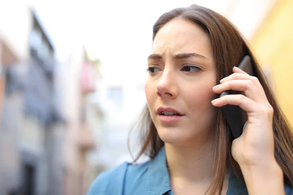 Worried woman talking on phone walking in the street — Stock Photo, Image