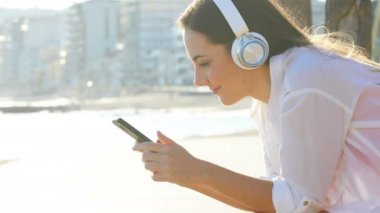 Akıllı telefon Coast müzik dinlerken mutlu bir kadın profili